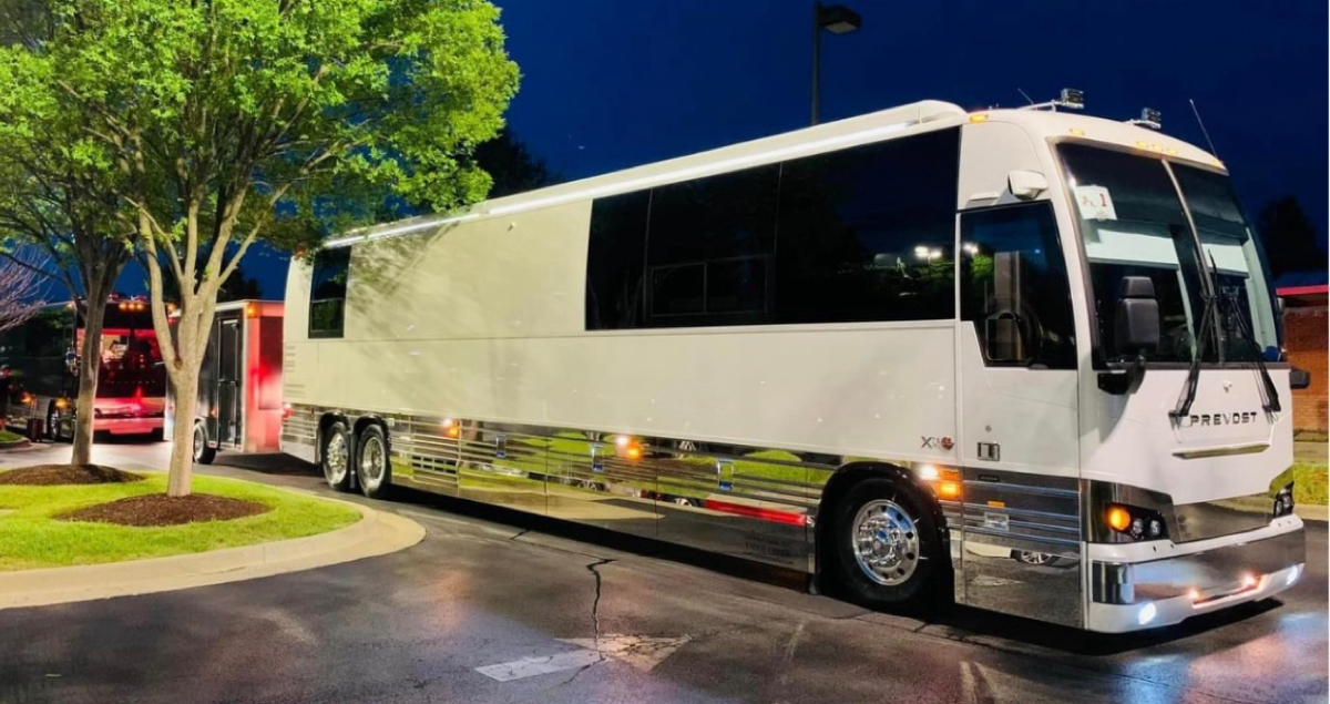 Autobus Prévost stationné de nuit près d’un trottoir, illustrant les avantages d’un entretien préventif pour les autobus MCI et Prévost, garantissant fiabilité, propreté et performance optimale.