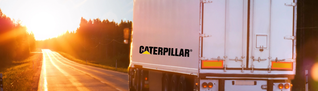 Camion sur route au coucher du soleil équipé d’un moteur diesel Caterpillar, illustrant la performance en transport longue distance